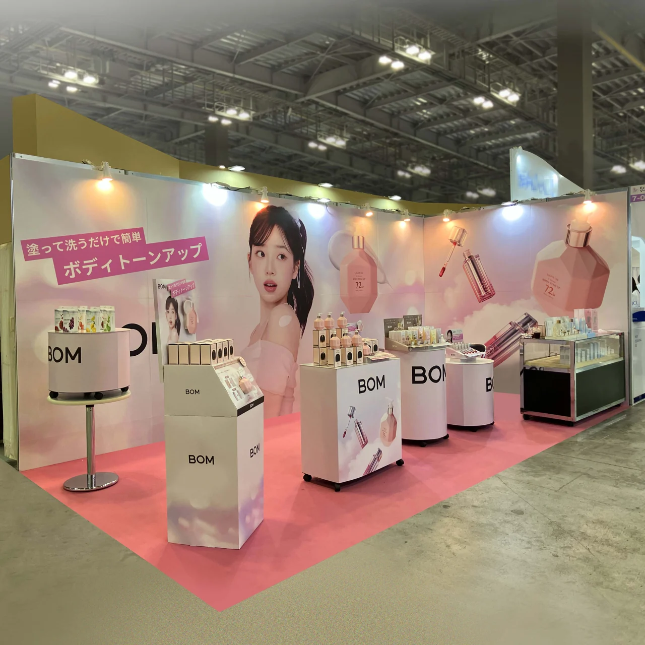 ピンクと白を基調に化粧品を陳列したBOM様のイベントブース